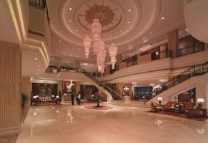 a lobby with a chandelier and a staircase in a building at Shangri-La Manzhouli in Manzhouli