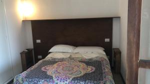 a bedroom with a bed with a large wooden headboard at Il Viandante in Recanati