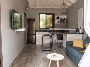 a living room with a couch and a kitchen at kokopoirier in Terre-de-Haut