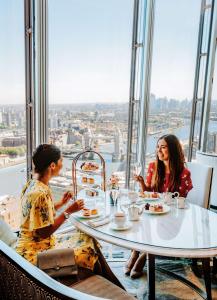 Deux femmes assises à une table dans un restaurant dans l'établissement Shangri-La The Shard, London, à Londres