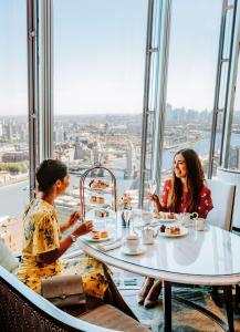 two women sitting at a table in a restaurant at Shangri-La The Shard, London in London
