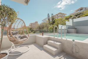 a balcony with a hammock and a swimming pool at Onirion Homes : Stella's Home in Kolymvari