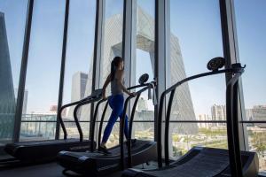 a woman walking on a treadmill in a gym at JEN Beijing by Shangri-La in Beijing