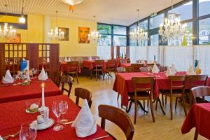 a restaurant with red tables and chairs and chandeliers at Good Night Inn in Brig