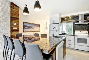 una cocina con una gran mesa de madera y sillas en 52 Chemin de la Perdrix, en Stoneham