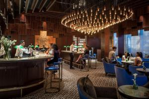 a restaurant with a bar and people sitting at tables at Shangri-La Colombo in Colombo