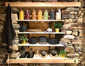 a shelf with plates and vases on a stone wall at La Maison des Vignes - Terrasse & balcon in Morlaix +35 photos