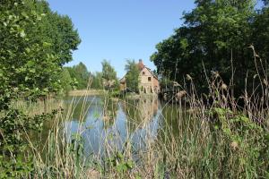 een huis aan de kant van een meer bij Schmiede der Wasserburg Liepen in Gielow