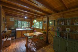 a kitchen with a table and chairs in a cabin at Mindo Eco Chalet con Rio y Cascada in Mindo