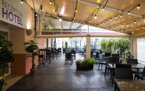 タラスコン・シュル・アリエージュにあるHôtel Le Bellevueのテーブルと椅子、照明が備わる空きレストランです。