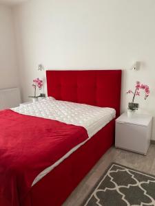 een rood bed met een rood hoofdeinde in een slaapkamer bij Apartament RUBINOWY Pięć Mórz - Sianożęty in Sianozety