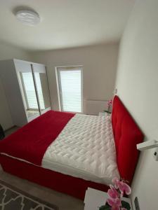 een slaapkamer met een groot bed en een rode deken bij Apartament RUBINOWY Pięć Mórz - Sianożęty in Sianozety