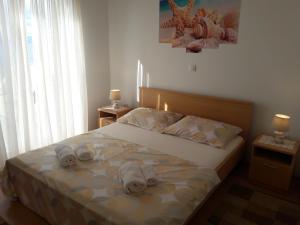 una camera da letto con un letto e asciugamani di Apartmani Prpić a Sveti Juraj