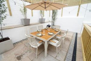 a table with chairs and an umbrella on a patio at 11 Breakwaters Way - Sandown in Sandown