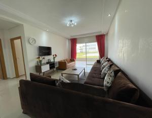 a living room with a couch and a table at Très bel appartement à OLA BLANCA in Sidi Rahal