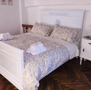 - une chambre dotée d'un lit blanc avec un couvre-lit et des oreillers blancs dans l'établissement Cà del Bunimur, à Magliano Alpi