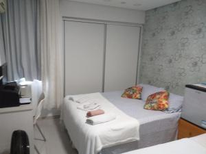 a bedroom with a bed with two towels on it at Quarto TRIPLO CONFORTO HH em RECIFE in Recife