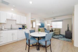Parks Residential-Richardson في ريتشاردسون: مطبخ وغرفة معيشة مع طاولة وكراسي