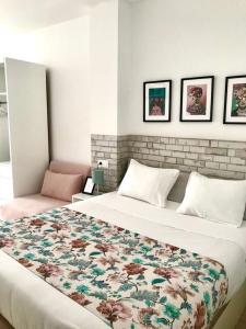 a bedroom with a large bed with a floral blanket at Apartamentos Élite - Art Collection - Frida in Merida
