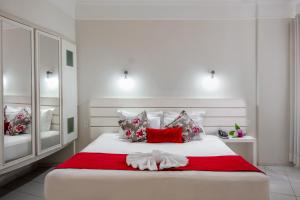 a bedroom with a white bed with red and white pillows at Tower Franca Hotel in Franca