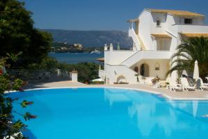 a swimming pool in front of a villa at Maison Metel in Kontokali