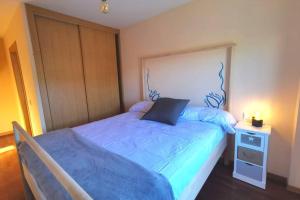 sypialnia z niebieskim łóżkiem i szafką nocną w obiekcie Apartamento con vistas al mar, playa de Carnota! w mieście San Mamede de Carnota