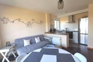 salon z niebieską kanapą i kuchnią w obiekcie Apartamento con vistas al mar, playa de Carnota! w mieście San Mamede de Carnota