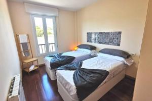 sypialnia z dwoma łóżkami i oknem w obiekcie Apartamento con vistas al mar, playa de Carnota! w mieście San Mamede de Carnota