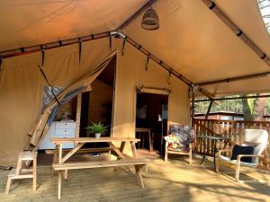 Camp Bursztynowy Las في غدانسك: خيمة فيها طاولة وكراسي