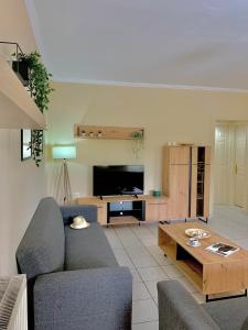 a living room with a couch and a table at Olive Tree Apartments in Lefkada Town