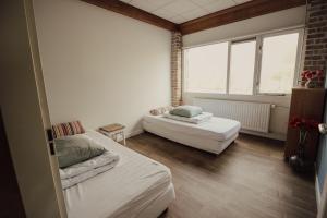 Habitación pequeña con 2 camas y ventana en 't Wagenhuis, en Retranchement