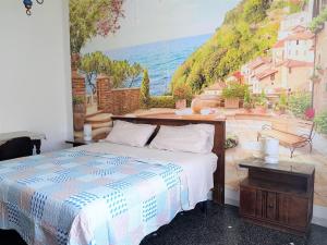 een slaapkamer met een bed en een schilderij van de oceaan bij Mare & Relax in Albissola Marina