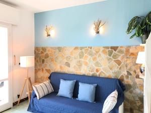 Sofá azul en una habitación con pared de piedra en Un Passo dal Mare, en Zoagli