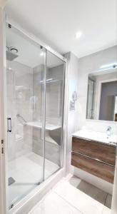 a bathroom with a glass shower and a sink at Hotel Mira-Mar in Valras-Plage