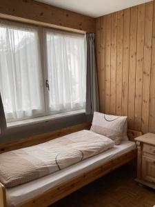 a bed sitting in a room with a window at Hotel Scuol in Scuol