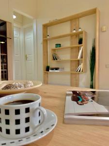 a cup of coffee and a book on a table at Olive Tree Apartments in Lefkada Town