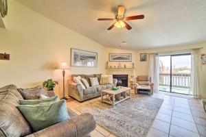 a living room with a couch and a ceiling fan at Canalfront Retreat with Dock, Hot Tub and Pool Access! in Corpus Christi
