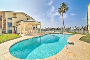 a swimming pool in front of a house with a palm tree at Waterfront Luxury House: Dock, Fire Pit & Fishing in Corpus Christi