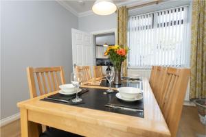 a dining room with a wooden table with chairs and a dining room at Merlin House in Cockfield