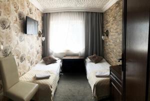 a hotel room with two beds and a window at Ośrodek Wczasowy REWA in Rewa