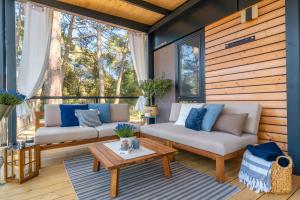 a porch with two couches and a coffee table at Mobile Homes AZZURRO in Rovinj