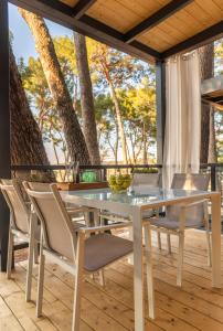 un tavolo da pranzo bianco e sedie su una terrazza di Mobile Homes AZZURRO a Rovigno (Rovinj)