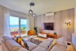 Una sala de estar con un sofá y un televisor. en Villa Matan - only 200m from the sandy beaches, private 28m2 pool, en Omiš