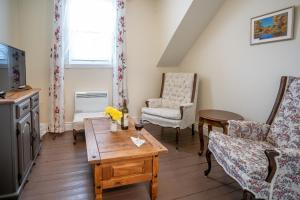 ein Wohnzimmer mit Couchtisch und Stühlen in der Unterkunft Au Coeur De Magog in Magog-Orford