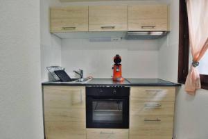 Il comprend une petite cuisine équipée d'une cuisinière et d'un évier. dans l'établissement Superbe appartement au centre de Samoens, à Samoëns