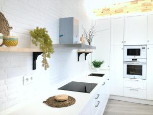 a kitchen with white cabinets and a counter top at Alojamiento Hermanos Garnelo in Montilla
