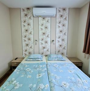 Székely Ház في شوبرون: غرفة نوم صغيرة بسريرين مع شراشف زرقاء