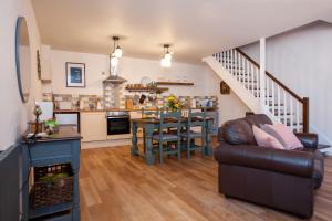 a living room with a couch and a table and a kitchen at The Old Chapel Leyburn in Leyburn