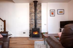 a living room with a fireplace and a couch at The Old Chapel Leyburn in Leyburn