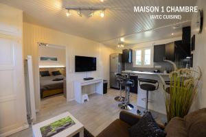 a living room with a kitchen and a living room with a couch at Casa Méline in Montry